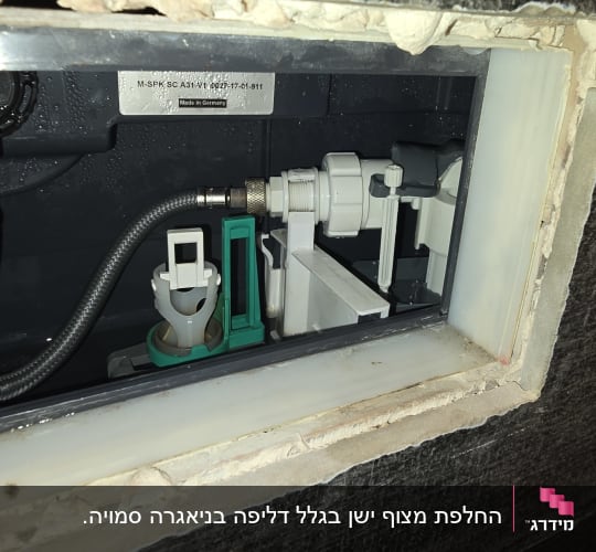 מנגנון פנימי של ניאגרה סמויה בקיר במהלך עבודת תיקון אינסטלציה